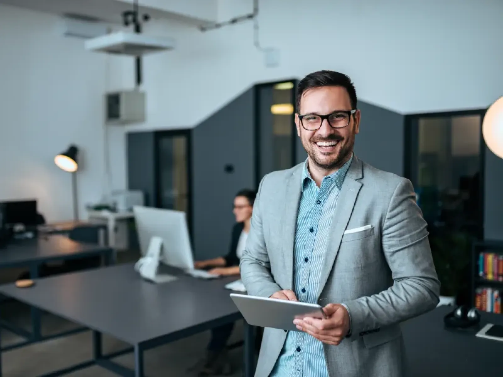 Smiling IT consultant holding a tablet in a modern office